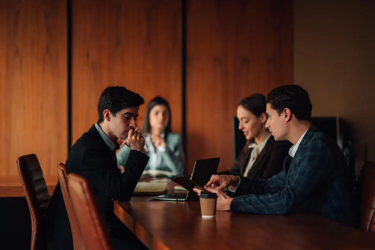 Business partners reviewing a contract dispute during a corporate boardroom meeting in California