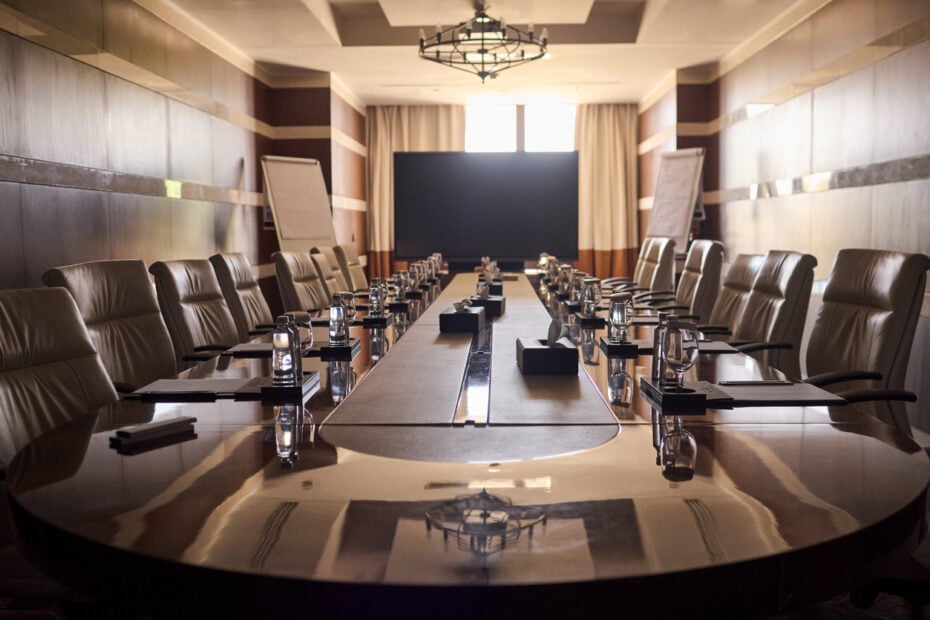 Luxurious executive boardroom setup highlighting corporate partnership dissolution, structural separation contracts, and asset division.