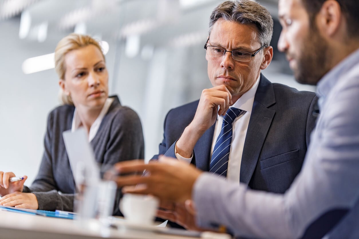 Corporate executives in a boardroom reviewing a sudden data exposure liability crisis.