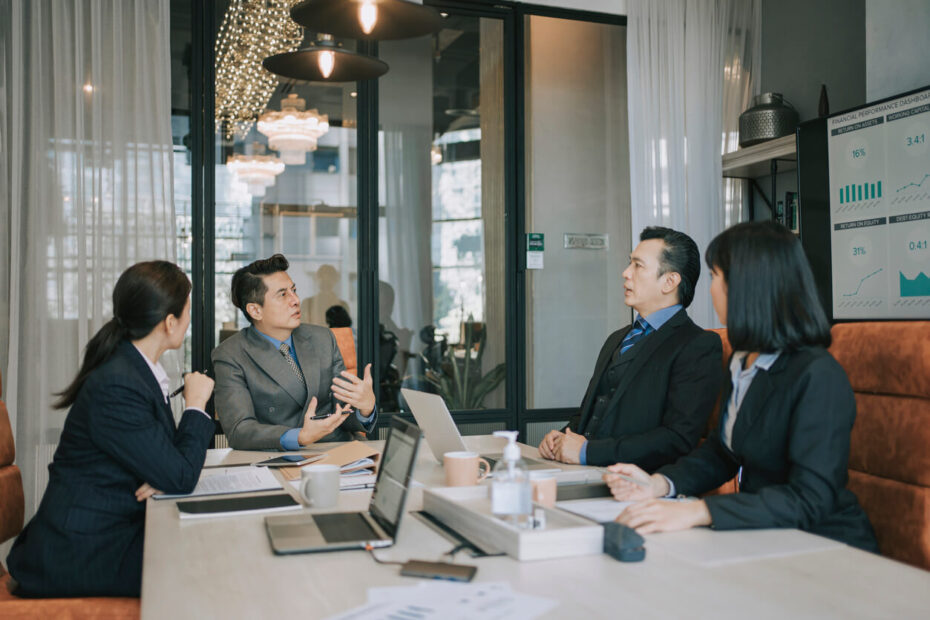 Corporate executives in a high-end boardroom experiencing an argument and contract dispute over uncontracted business collaboration rights.