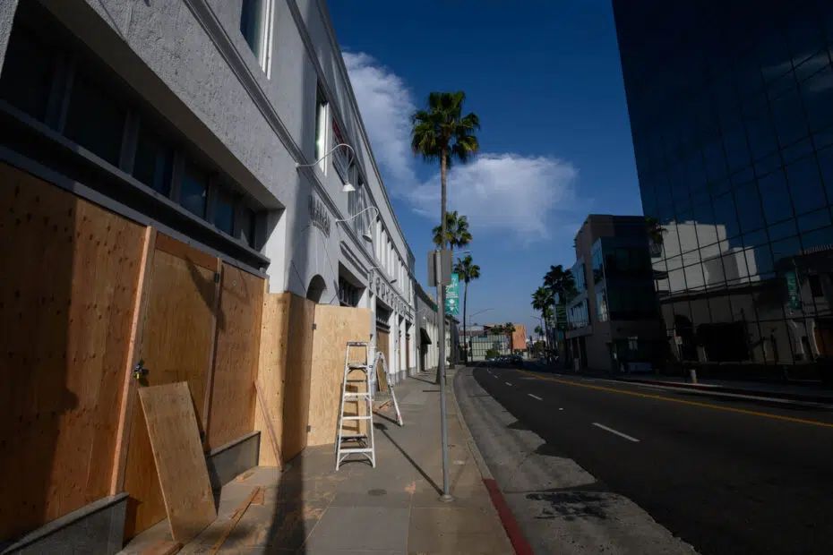 Boarded up luxury commercial storefront in Beverly Hills highlighting lease default risks.