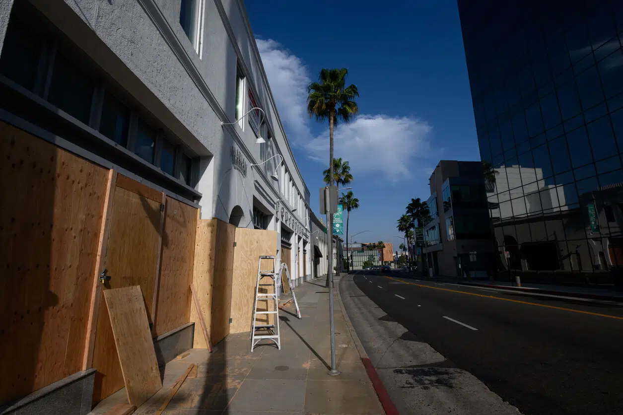 Boarded up luxury commercial storefront in Beverly Hills highlighting lease default risks.