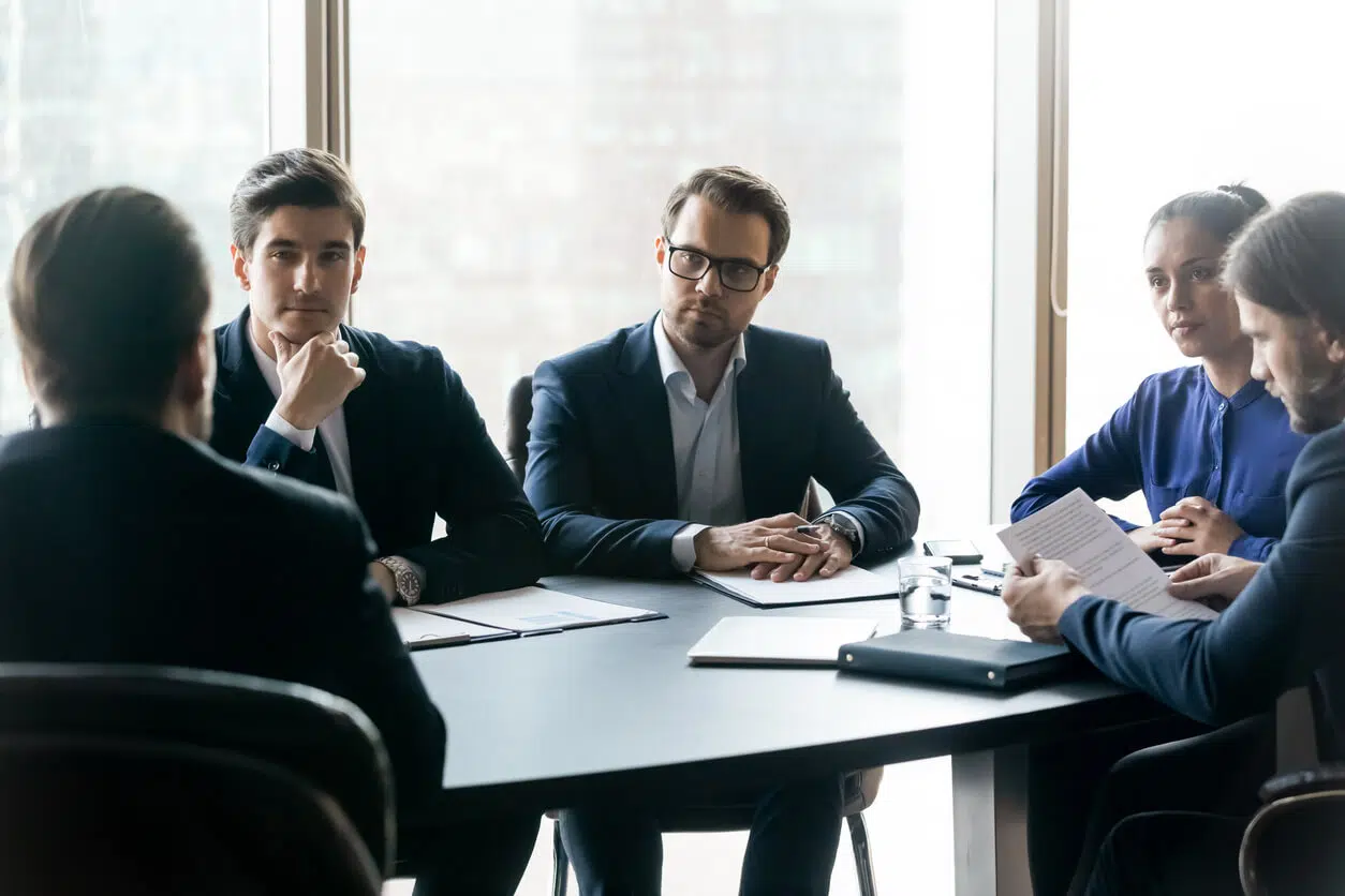 Serious corporate dispute meeting in a boardroom highlighting a material breach of contract legal issue.